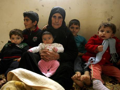 Hallum Al-Amin, a Syrian refugee, sits with members of her family in a house in the village of Qalawayeh, near the southern Lebanese town of Tyre; Amin has just marked her 100th birthday